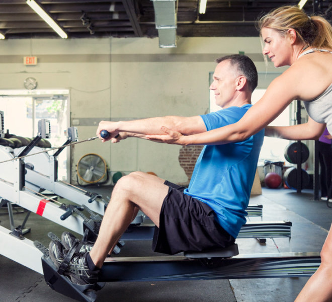 Personal trainer working with her client at a gym.